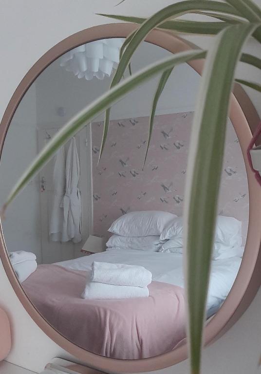 a bedroom with a round mirror over a bed at Home from Home Stay Margate in Margate