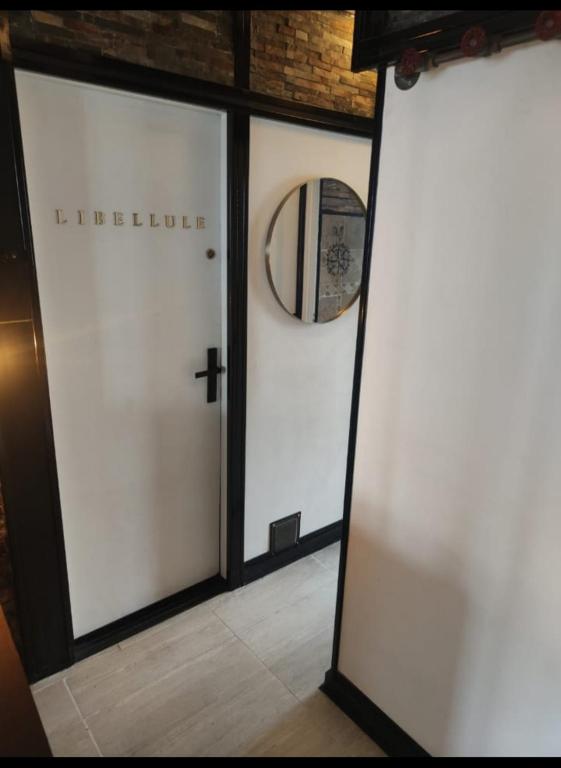 une paire de portes blanches avec une croix et un miroir dans l'établissement Libellule industrie, à Massy