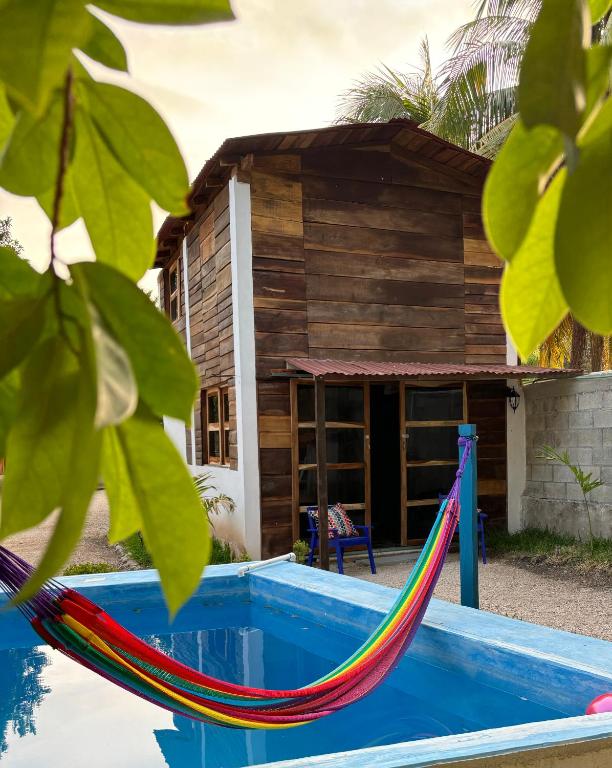 a house with a hammock in front of it at Cabana Bacalar in Bacalar