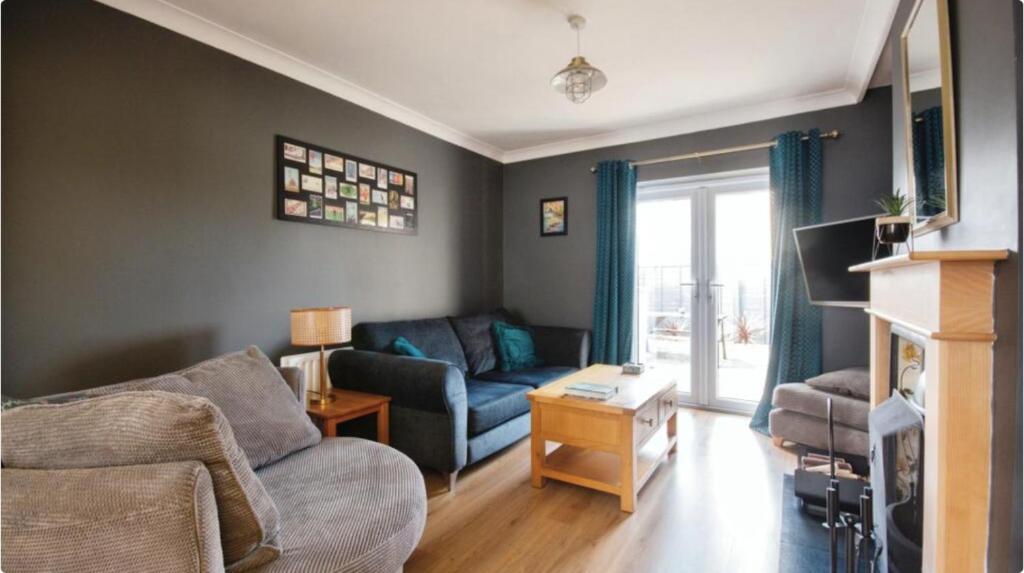 uma sala de estar com um sofá e uma mesa em Cosy home from home em Bournemouth