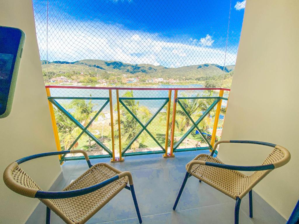 2 Stühle auf einem Balkon mit Aussicht in der Unterkunft Casa García Rent Home in Guatapé