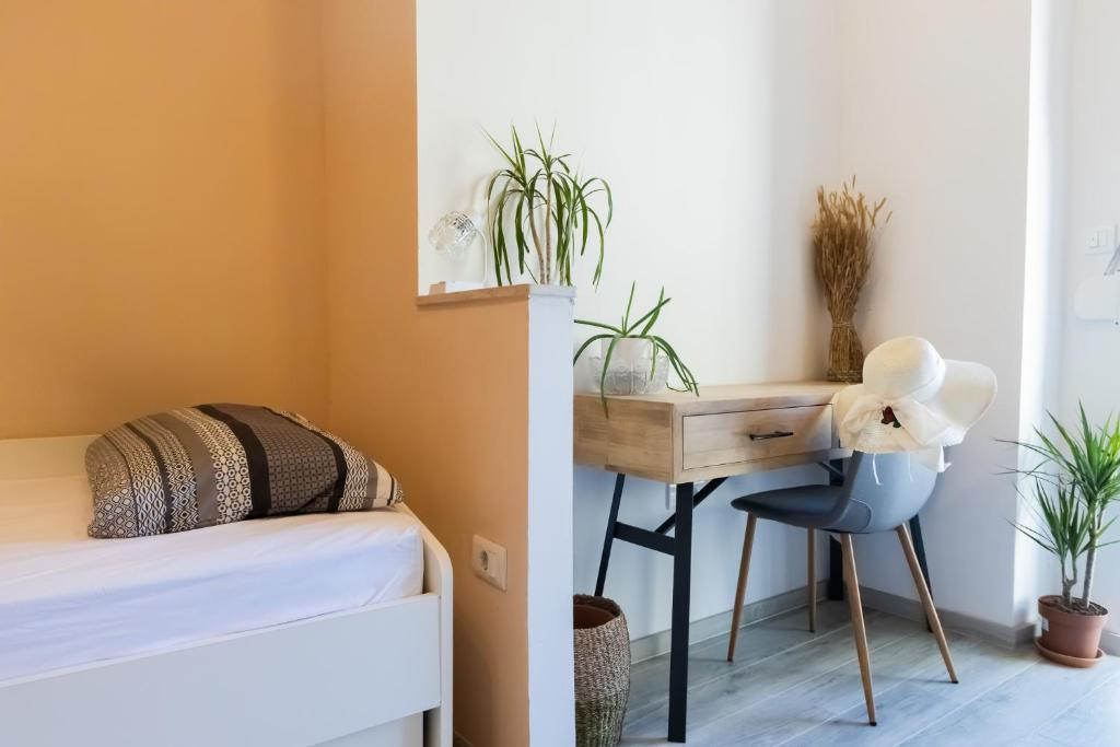 Schlafzimmer mit einem Bett und einem Schreibtisch mit Pflanzen in der Unterkunft City center apartment Azura Vista in Poreč