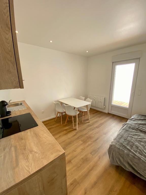 ein Schlafzimmer mit einem Tisch und einem Bett sowie eine Küche in der Unterkunft L'échappée belle d'Albi in Albi