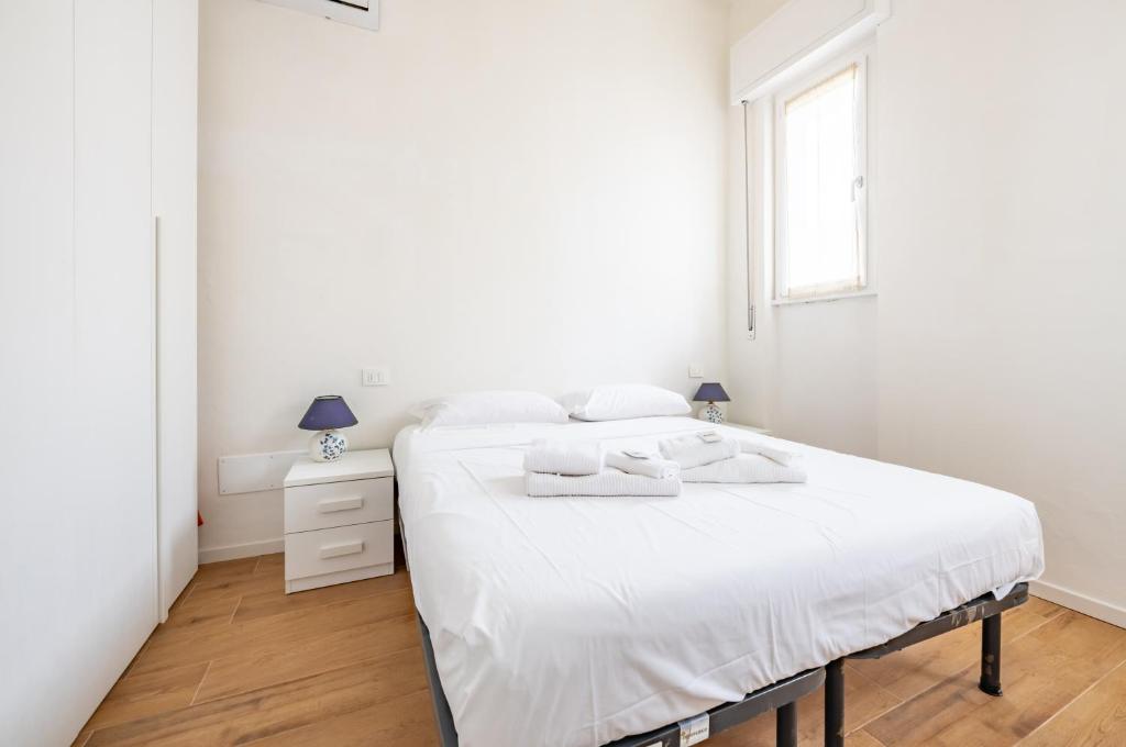 ein weißes Schlafzimmer mit einem Bett und einem Fenster in der Unterkunft Deiva Marina Sea House! Functional Apartment in Deiva Marina