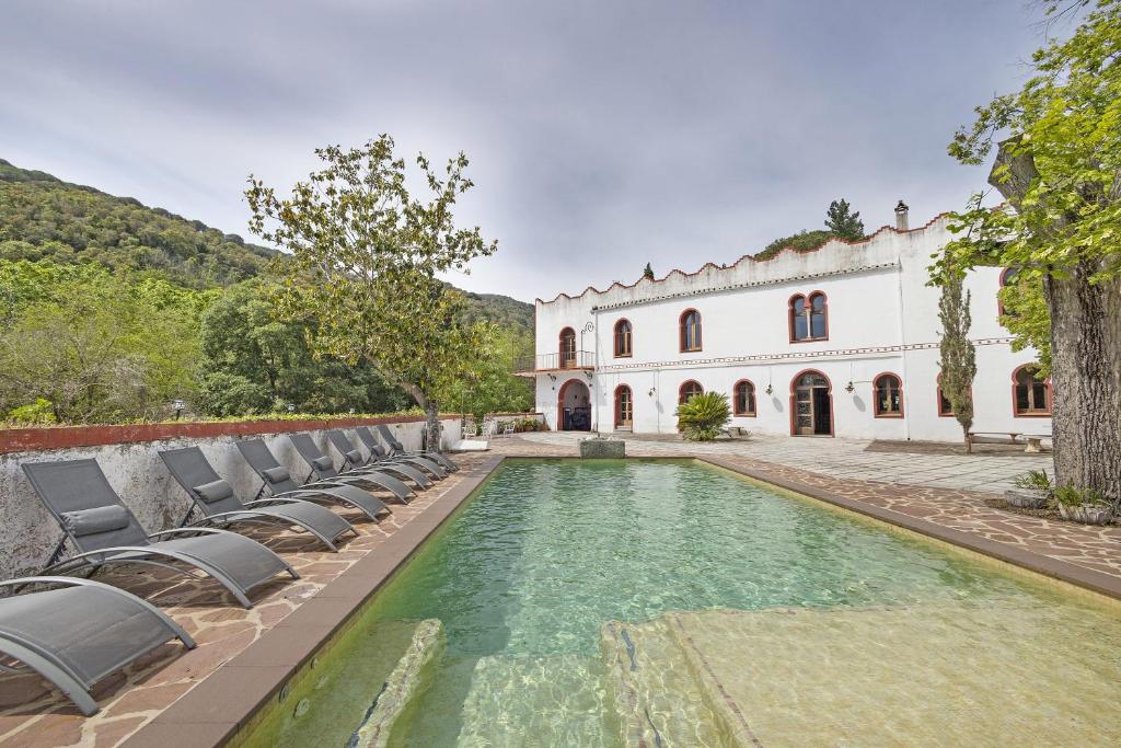 ein Grundstück mit einem Pool und Liegestühlen in der Unterkunft El Cortijo in Arenys de Munt