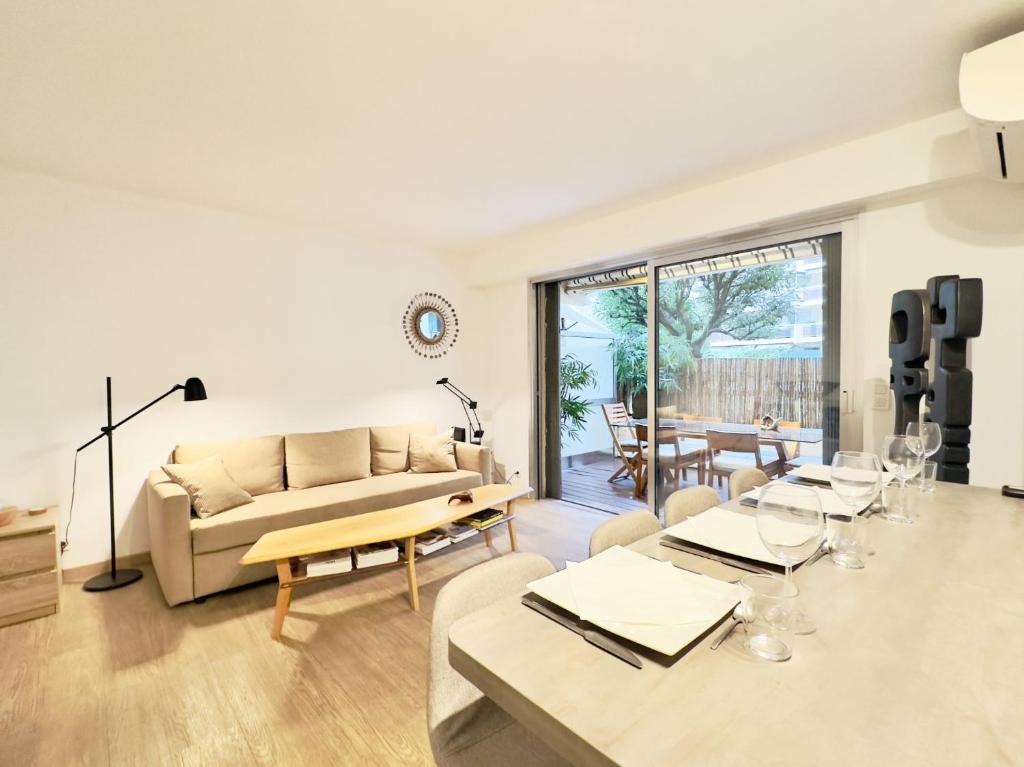 un salon avec un canapé et une table dans l'établissement L'ébène - Cannes Centre - Cozy, à Cannes