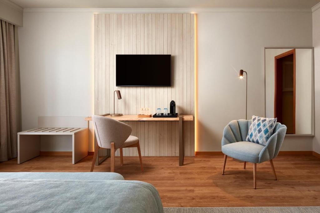 Uma TV ou centro de entretenimento em Dom Jose Beach Hotel (Plus)