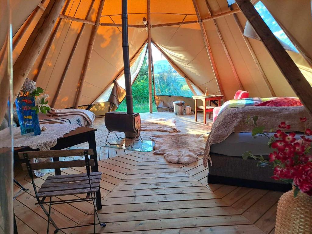 a tent with two beds and a wooden floor at Strandheimen Guesthouse in Melhus