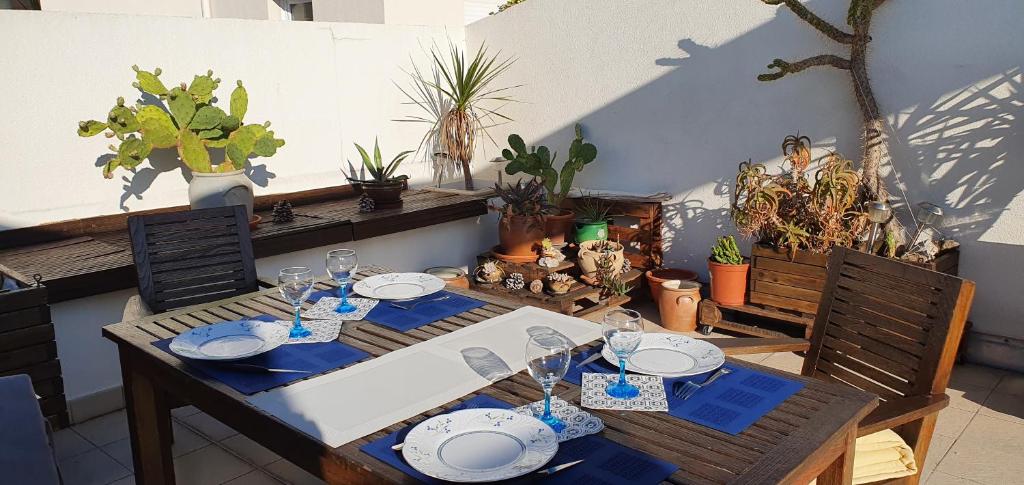 une table avec des assiettes et des verres à vin dessus dans l'établissement appartement avec terrasse tropézienne, à Fréjus