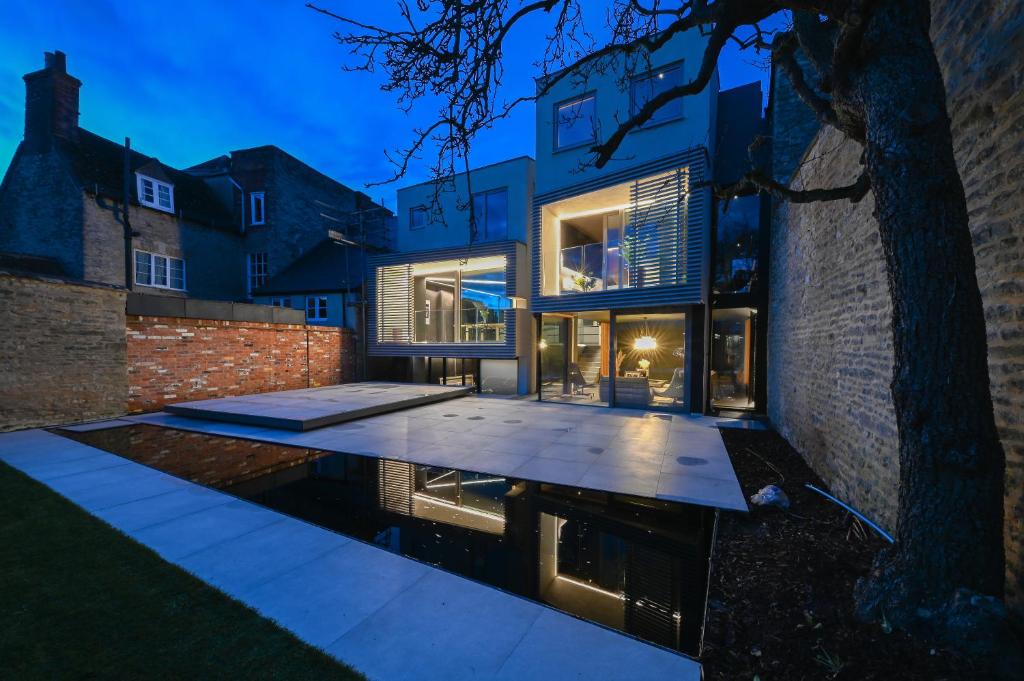 a house with a pool in front of a brick building at Luxury Villa in Central Woodstock in Woodstock