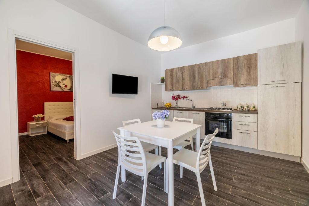 a kitchen and dining room with a white table and chairs at Case Vacanza Loria in Castelluzzo