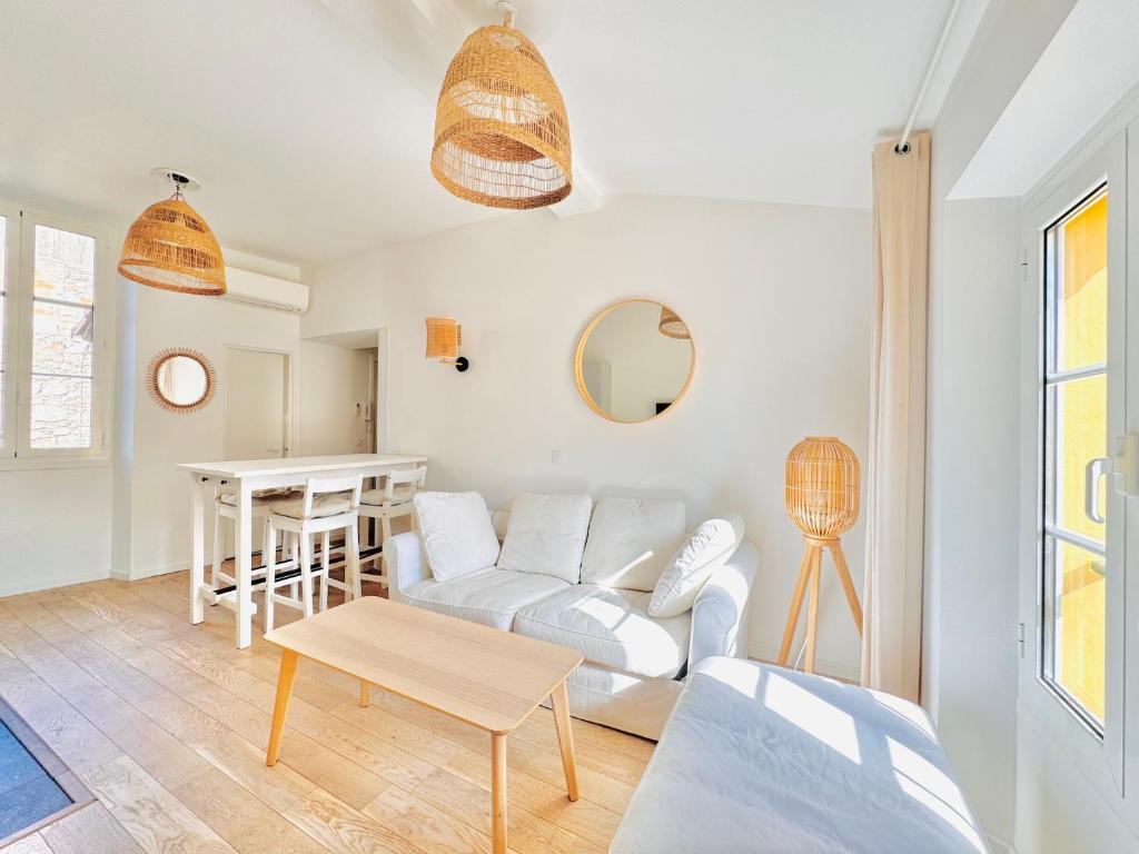 un salon avec un canapé blanc et une table dans l'établissement Le Bohème - Logement Cozy centre, à Cannes