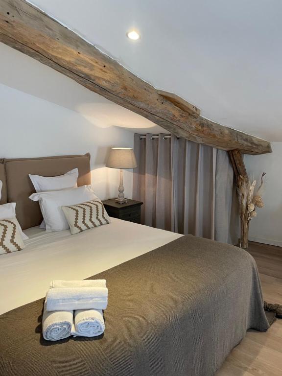 a bedroom with a bed with two towels on it at La Maison du Clocher in Saint-Émilion