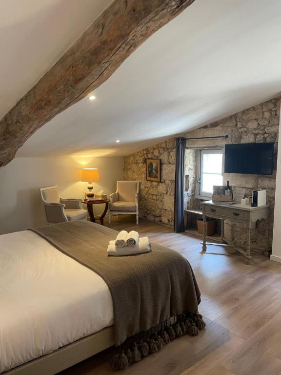 a bedroom with a bed and a desk in a room at La Maison du Clocher in Saint-Émilion