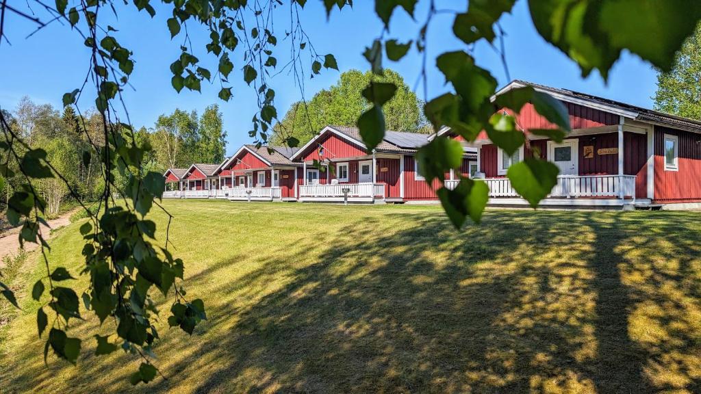 a row of red houses on a grass field at Gammal björn in Dalskog
