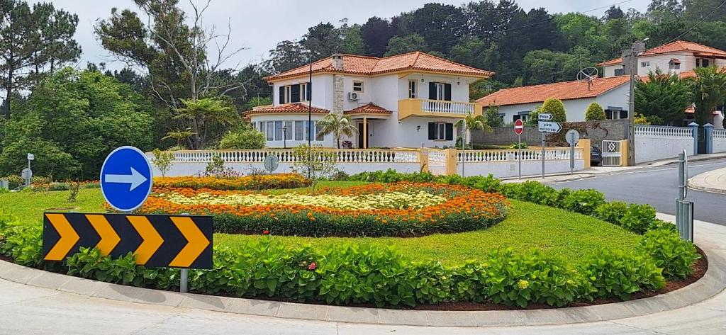 a sign in front of a house with a flower garden at Villa Familia Dehoux in Camacha