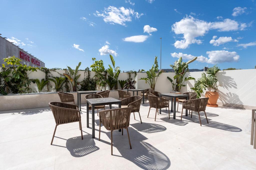 a patio with tables and chairs on a roof at ASA Hotel La Marina in Ondara