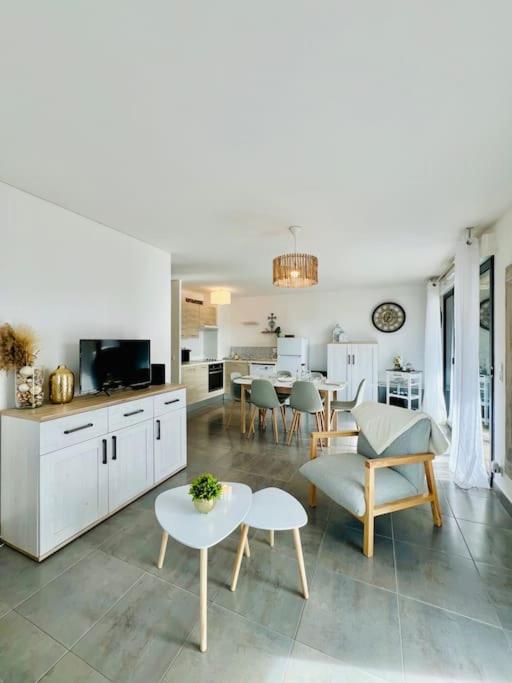une cuisine et un salon avec une table et des chaises dans l'établissement T3 cosy proche mer avec Parking, à Villeneuve-lès-Maguelone