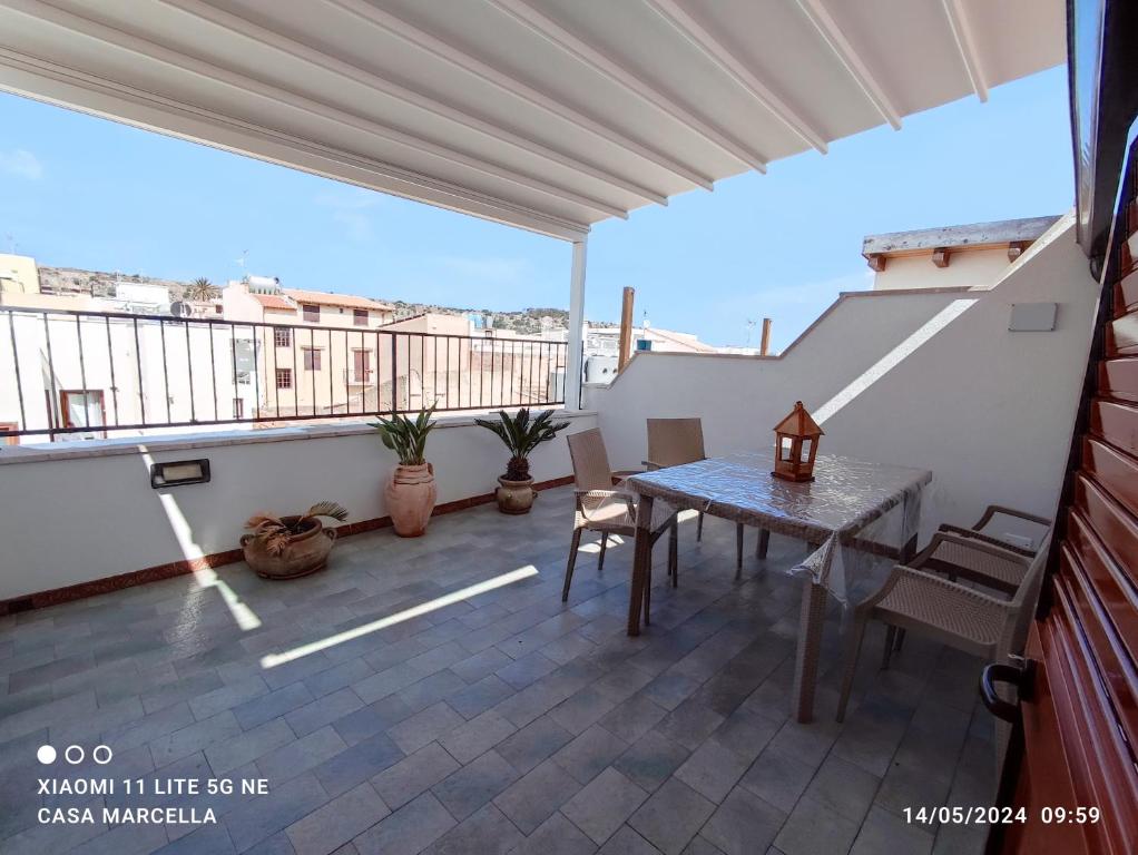 a patio with a table and chairs on a balcony at Casa Marcella San Vito Lo Capo in San Vito lo Capo