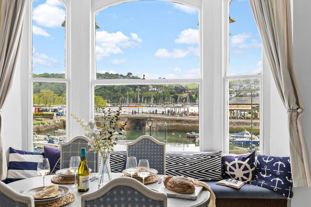 a dining room with a table and a large window at Anchor Watch with Parking in Dartmouth