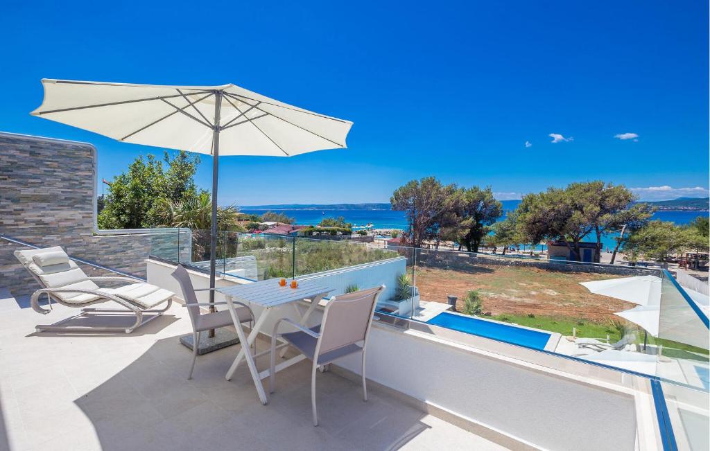 a patio with a table and chairs and an umbrella at Beach Front Home In Punat With Kitchen in Punat