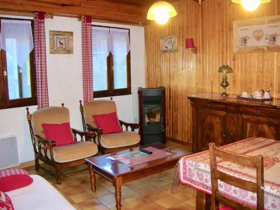un soggiorno con sedie, tavolo e camino di Maison de montagne proche des Angles a La Llagonne
