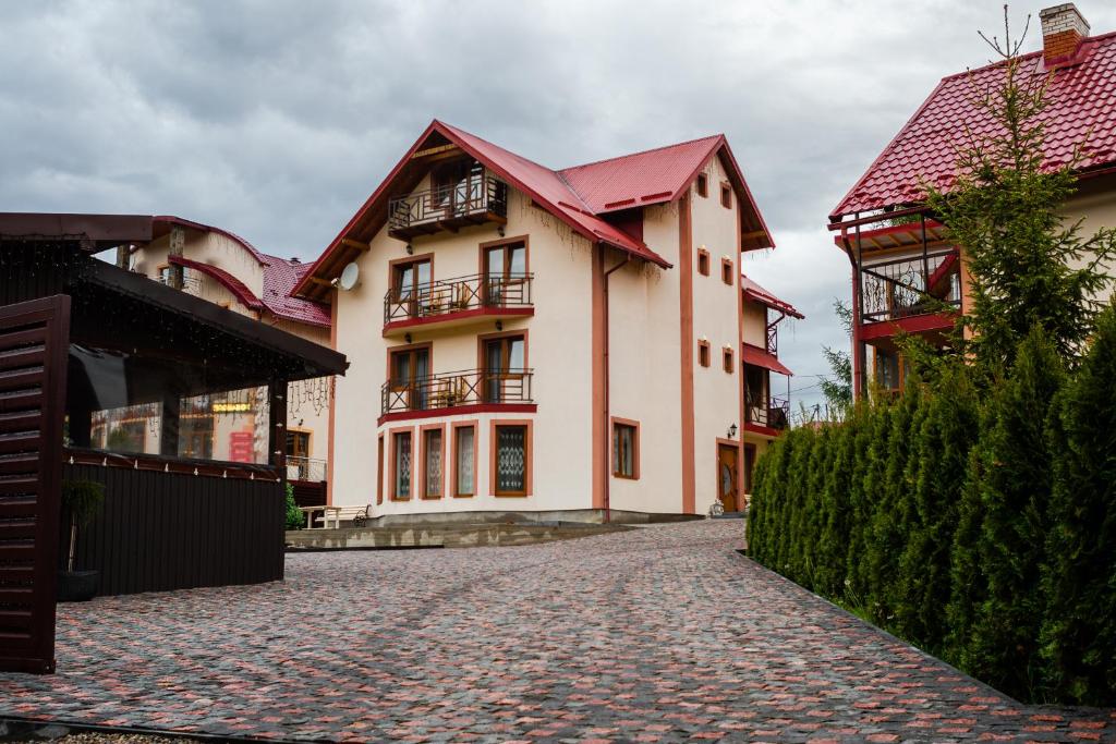 a building with red roofs on a cobblestone street at Melody Hotel in Bukovel