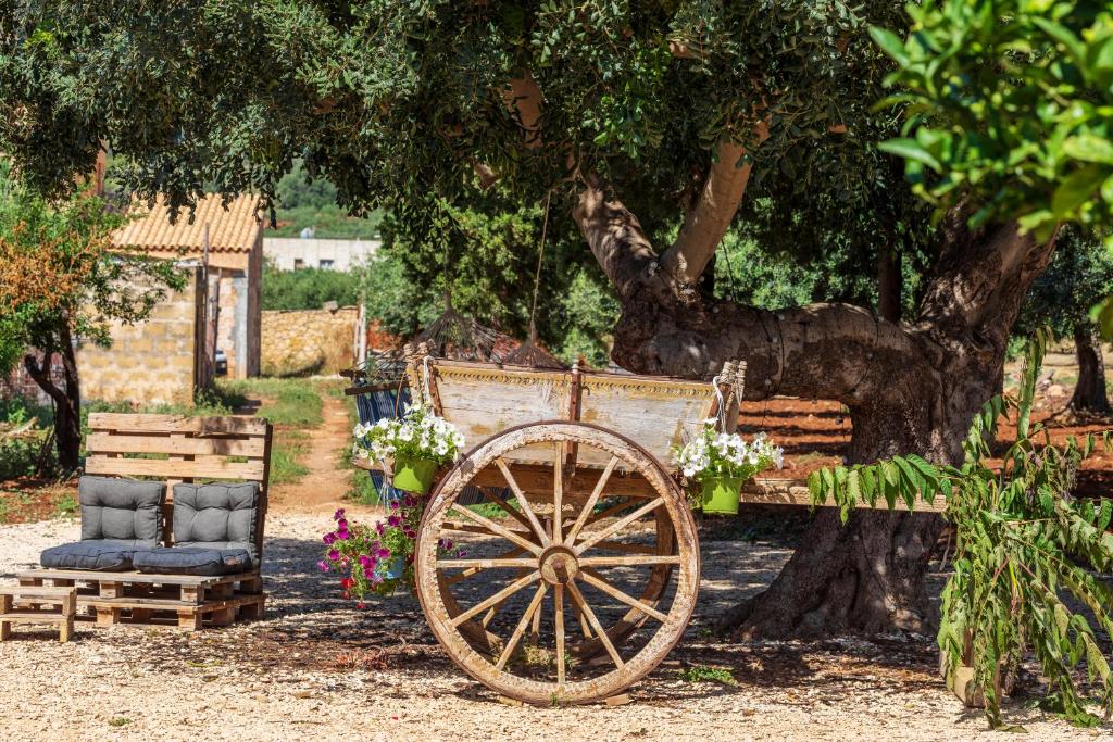 a wooden cart sitting in front of a tree at Case Vacanza Loria in Castelluzzo