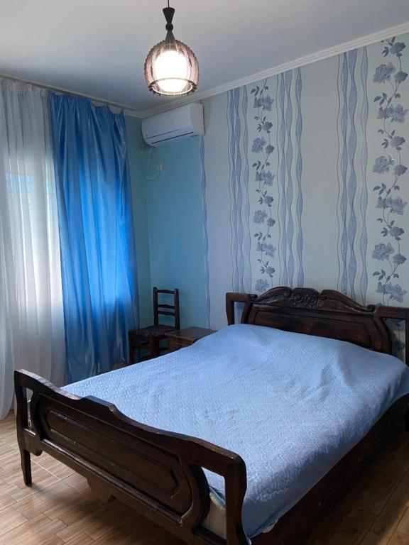 a bedroom with a bed with blue walls and a lamp at Guesthouse Mirabela in Shekvetili
