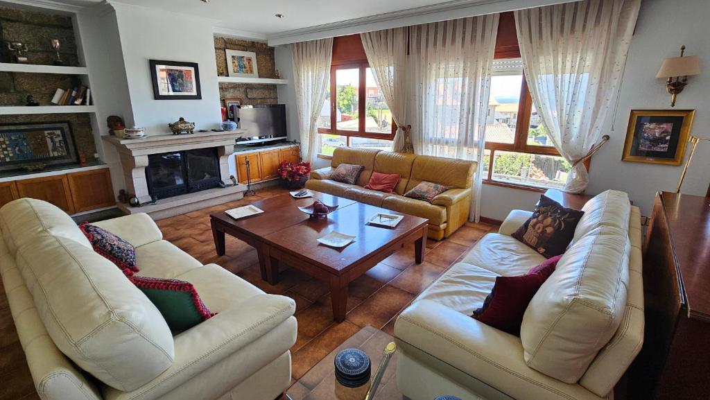 a living room with two couches and a table at CASA MEXILLOEIRA in O Grove