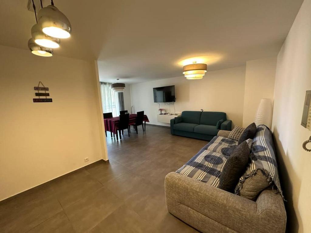 un salon avec un canapé et une salle à manger dans l'établissement C058 Bel appartement spacieux terrasse Centre, à Cannes