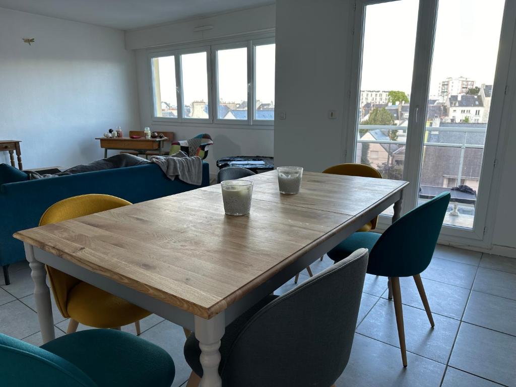 - une table en bois dans une chambre avec des chaises dans l'établissement Merville, à Lorient