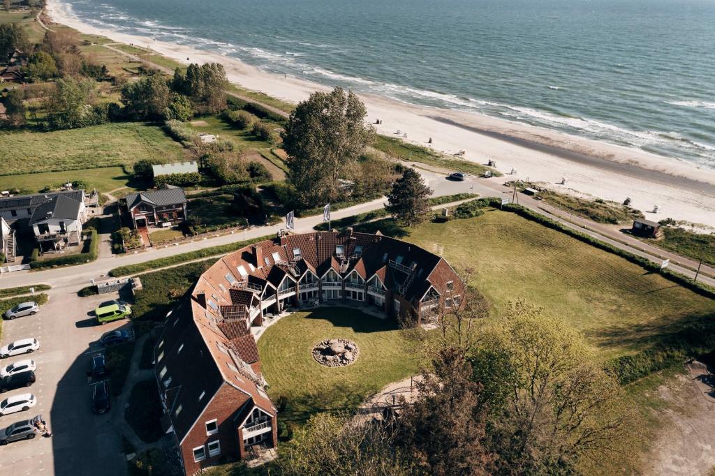 uma vista aérea de uma casa ao lado da praia em Ferienwohnung "Ostseeperle" direkt am Ostseestrand em Kronsgaard