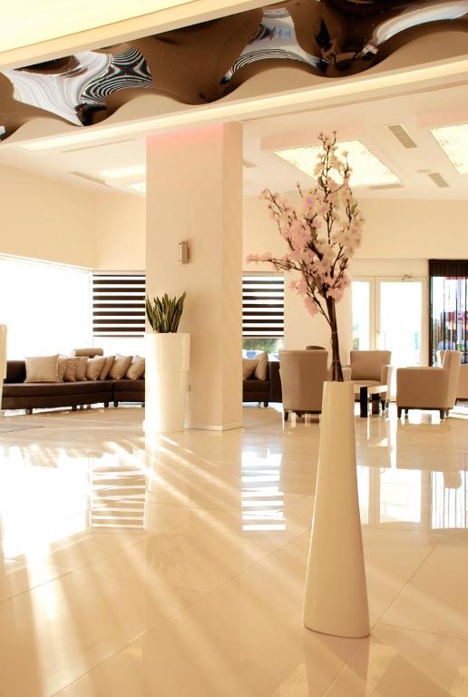 a lobby with two white vases with flowers in it at Orty Airport Hotel in Izmir
