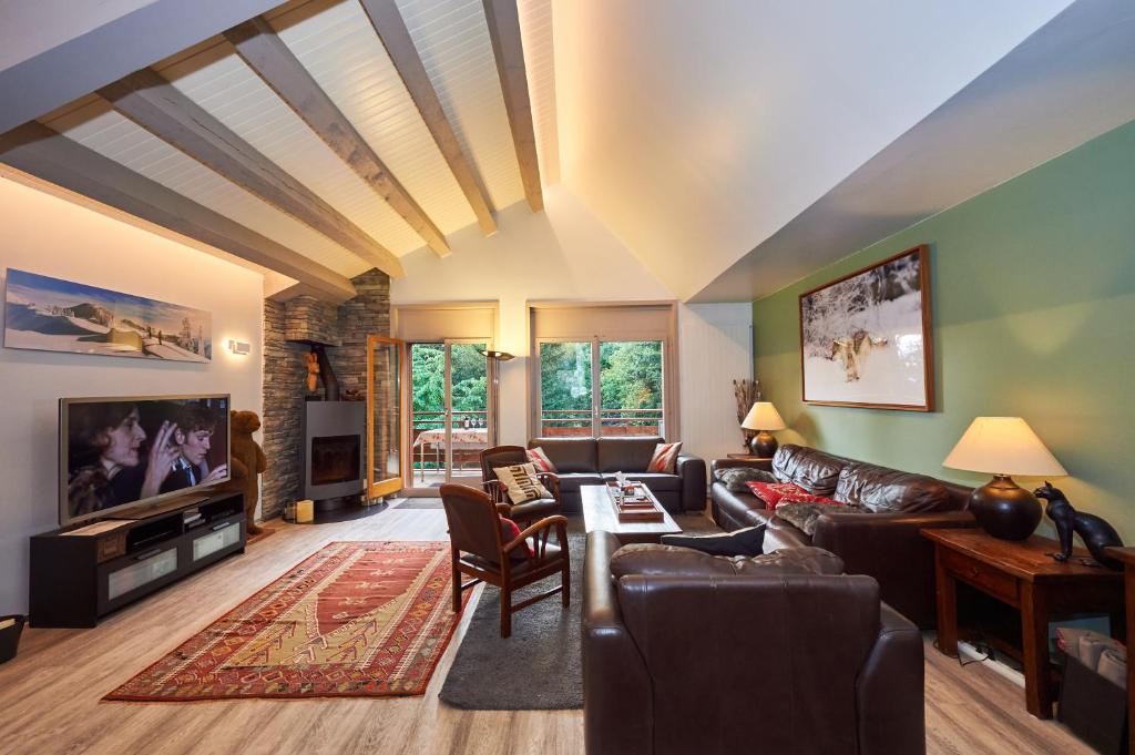 ein Wohnzimmer mit einem Sofa und einem Tisch in der Unterkunft Residence Tsaumiau, 3BR, Perfect View, Skilift 170m! in Crans-Montana
