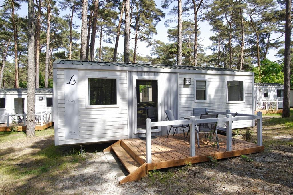 a small trailer with a deck and a table at Tiny Chalet Nr 816 in Göhren