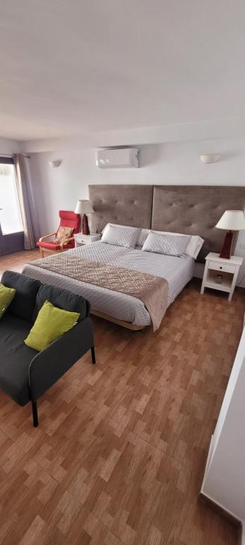 - une chambre avec un grand lit et un canapé dans l'établissement Apartamentos luna, à Ardales