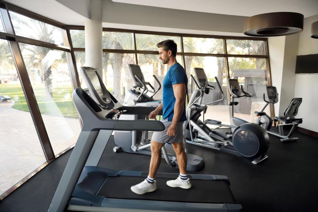 a man walking on a treadmill in a gym at InterContinental Abu Dhabi by IHG in Abu Dhabi