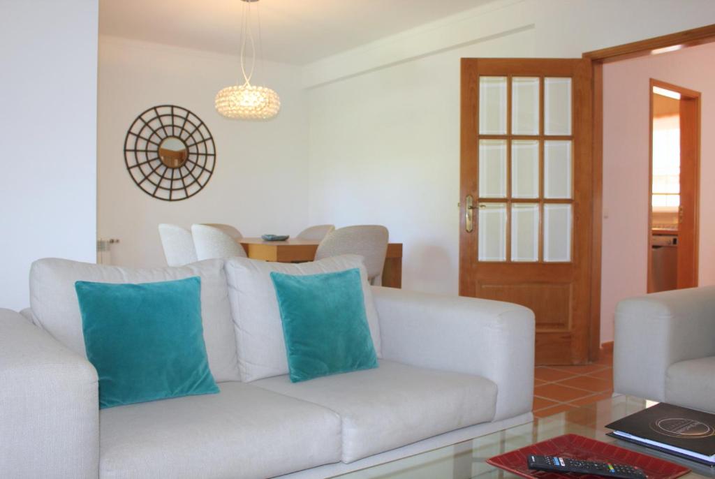 sala de estar con sofá blanco y almohadas azules en D. Duarte Townhouse, en Casal da Lagoa Seca