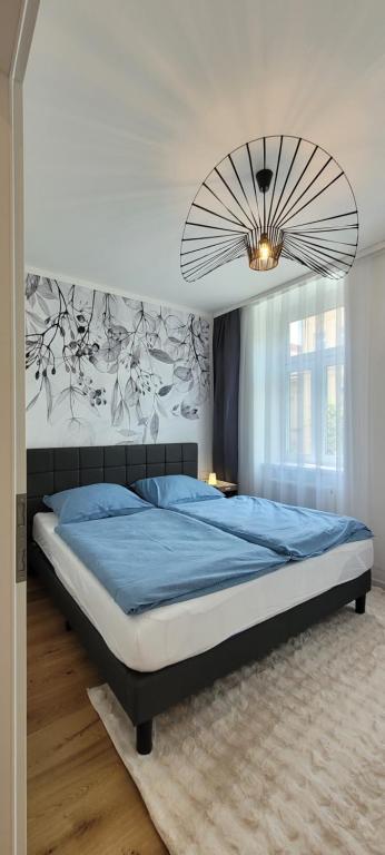 a bedroom with a large bed and a chandelier at Altbauwohnung mit Charme - selbst Check In - Queensize Bett in Vienna
