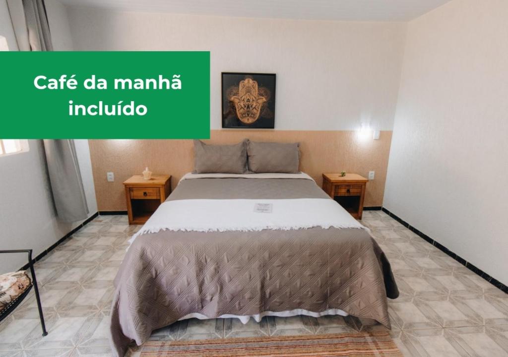 uma cama num quarto com um sinal verde que lê café da manila ind em Hotel Fazenda Bona Espero em Alto Paraíso de Goiás