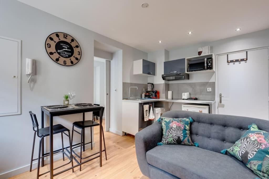 - un salon avec un canapé, une table et un réveil dans l'établissement Gioia - Sublime T1bis, à Toulouse