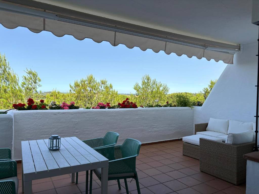 a patio with a table and chairs and a window at Luxury Hacienda Golf Islantilla in Islantilla