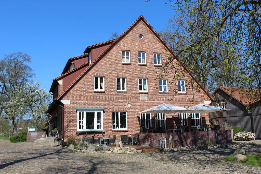 a large red brick house with white windows at Landgasthof Wildwasser in Wolthausen