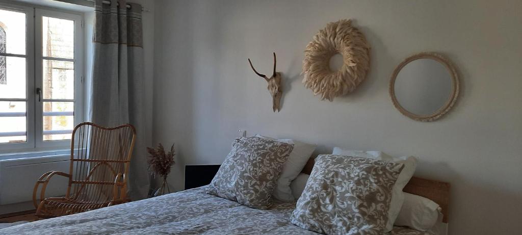 une chambre avec un lit avec deux oreillers et un miroir dans l'établissement Gîte du Lay, à Moutiers-sur-le-Lay