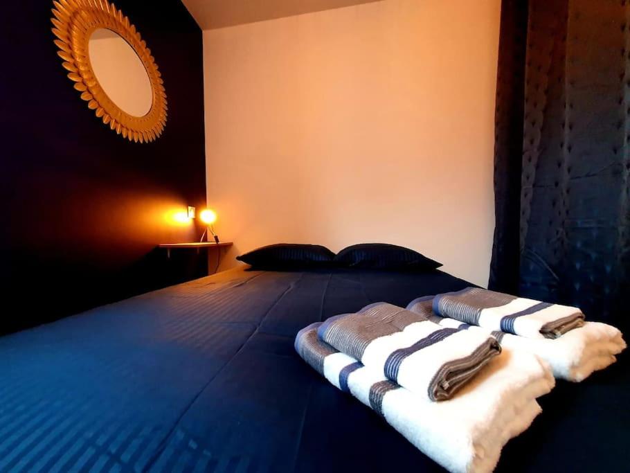 une chambre avec un lit avec deux serviettes dessus dans l'établissement LE REVE BLEU I Neuf I Parking gratuit I Proche Mer I Wifi haut débit, à Saint-Brieuc