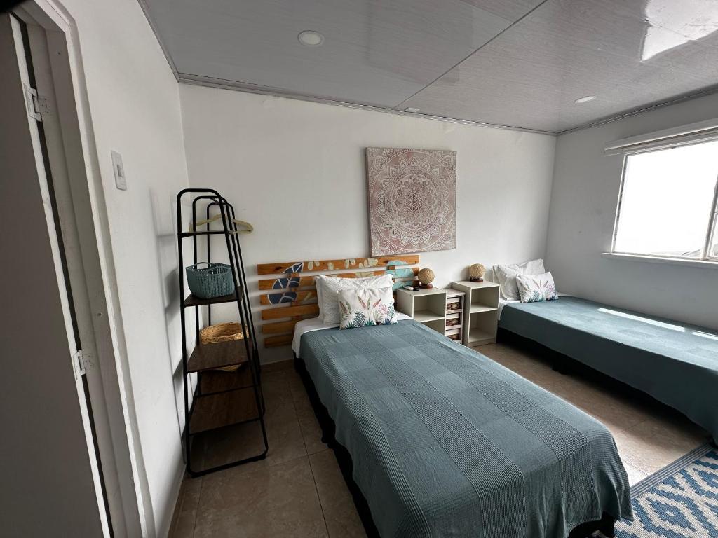 1 Schlafzimmer mit 2 Betten und einem Fenster in der Unterkunft Kalathea Casa in Tocaima