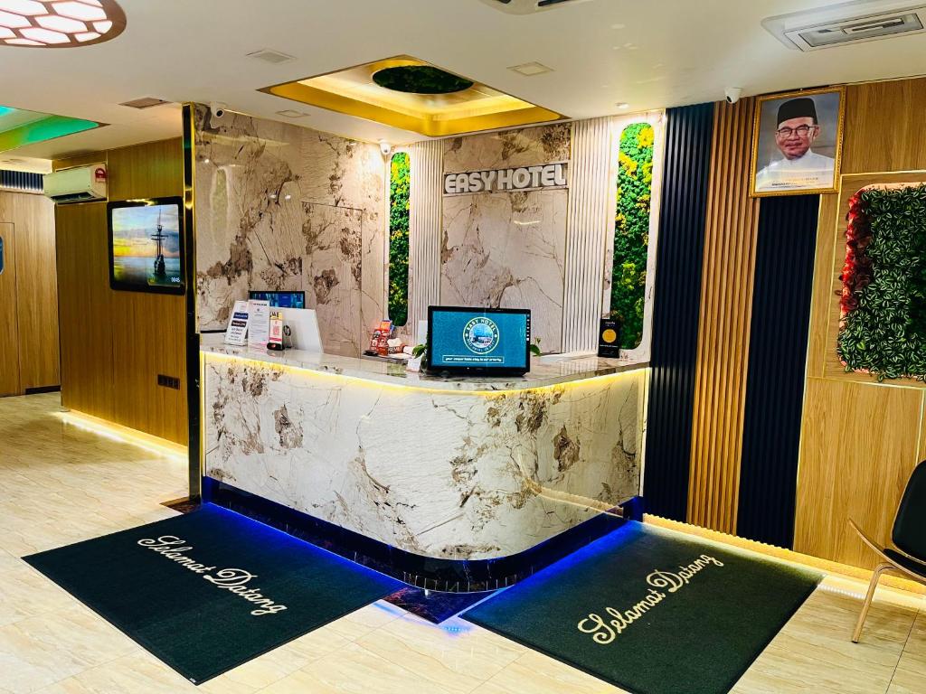 A polished reception desk with marble-effect finishes and illuminated hotel branding.