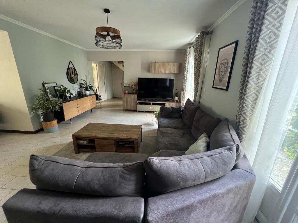 un salon avec un canapé et une table dans l'établissement Maison familiale proche Arpajon, à Égly