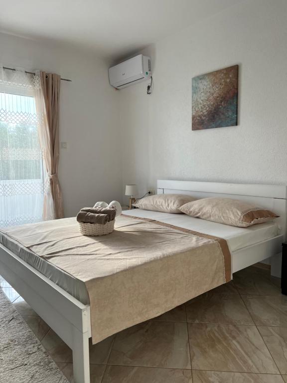 a bed in a white room with a large bed at Suka Apartments in Ulcinj